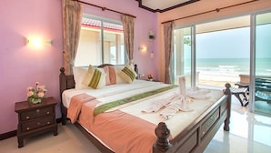 Un dormitorio con una cama grande, una mesita de noche y vistas a la playa.