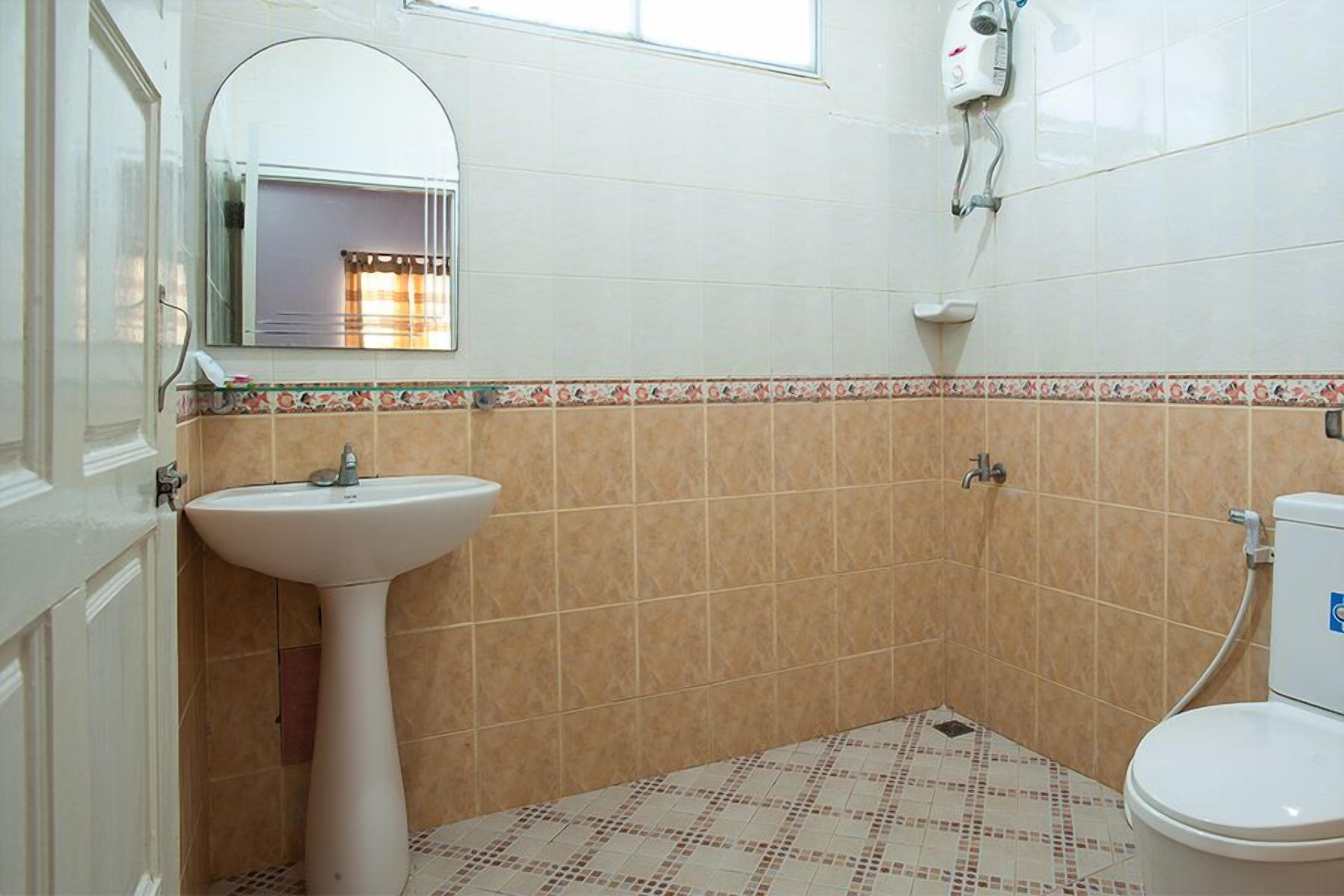 A bathroom with a pedestal sink, a toilet, and a shower.