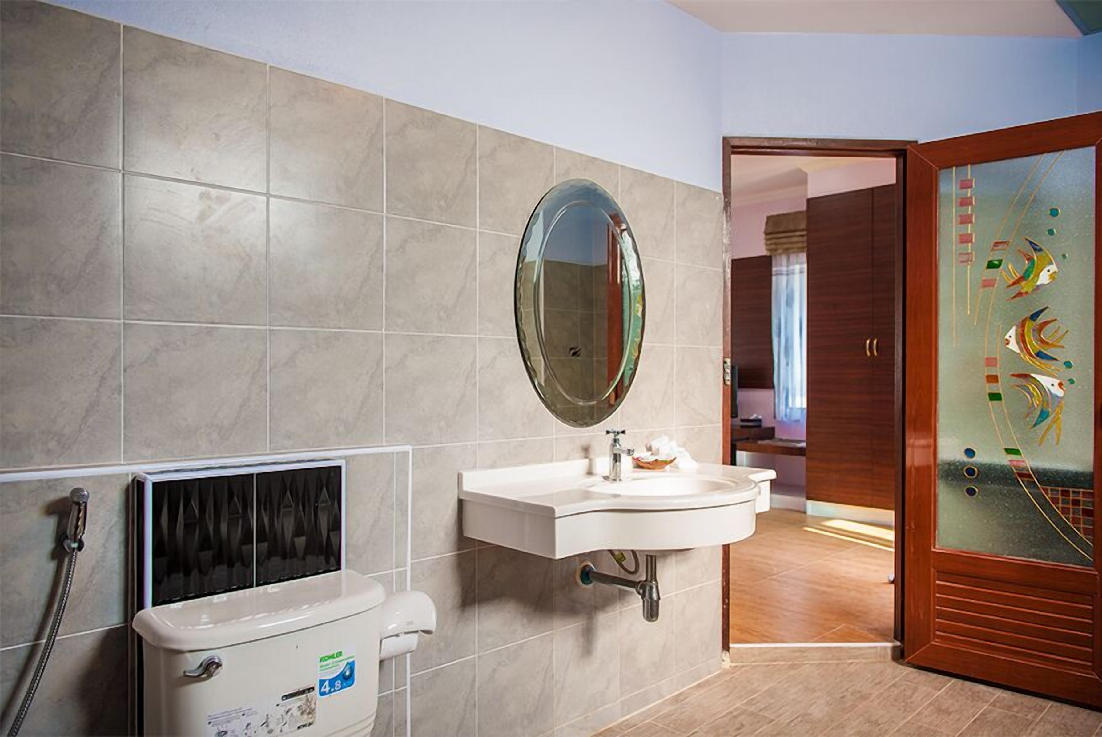Een badkamer met een wit wastafel, een spiegel en een toilet.