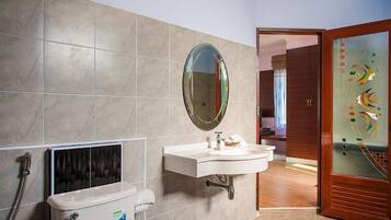 Een badkamer met een wit wastafel, een spiegel en een toilet.