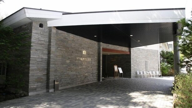 A building entrance with stone walls and a covered walkway. - Hotel Karuizawa Elegance (Karuizawa)