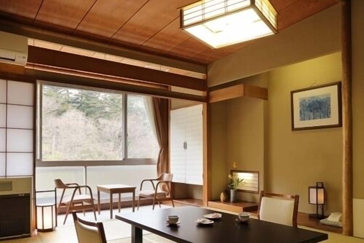 A traditional Japanese-style room with tatami flooring, a low table, and shoji screens.