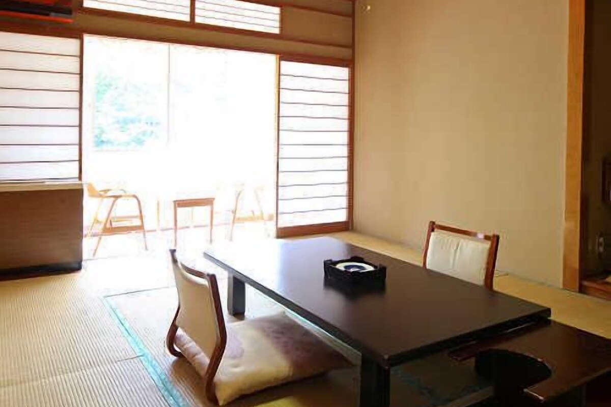 A traditional Japanese room with tatami flooring, a low table, and shoji screens.