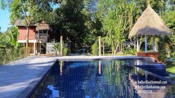 Una piscina al aire libre, sillones reclinables de piscina