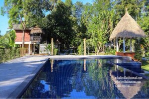 Una piscina al aire libre, sillones reclinables de piscina