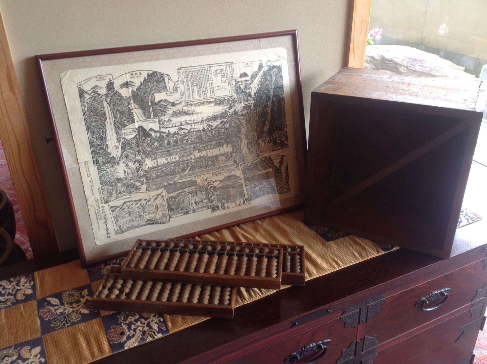 A framed map on a wooden dresser with drawers.