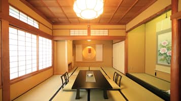 A traditional Japanese room with tatami flooring, a low table, and sliding doors.