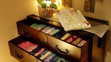 A wooden chest of drawers with colorful fabrics inside.