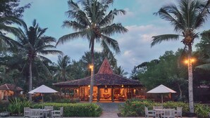 Ein Resort mit Pool, Sitzgelegenheiten im Freien und Palmen.