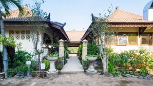 A traditional architectural structure with a central pathway leading to a covered area. - Rinjani Lodge (Bayan)