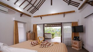 A hotel room with a large bed, a television, and a view of the outdoors. - Rinjani Lodge (Bayan)