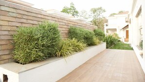 A modern building with a stone facade and a flat roof. - Pinto Rosario Square Resort and Spa (Guirim)