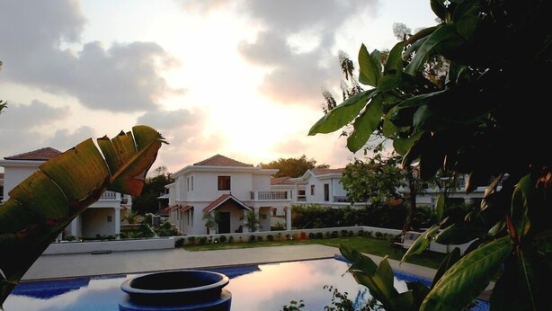 A resort with a swimming pool, white buildings, and lush greenery. - Pinto Rosario Square Resort and Spa (Guirim)