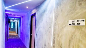 Un couloir d’hôtel avec des panneaux indicateurs indiquant les numéros de chambre 210-211 et 212-216.