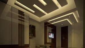 A modern living room with a sofa, a coffee table, and a flat-screen TV mounted on the wall. - Rezo's Hotel (Baga)