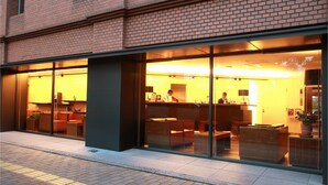 A modern building with large glass windows, a brick facade, and a reception area with seating. - Central Hotel Okayama (Okayama)