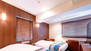 A hotel room with two beds, wooden paneling, a desk, and a window with blinds. - Central Hotel Okayama (Okayama)