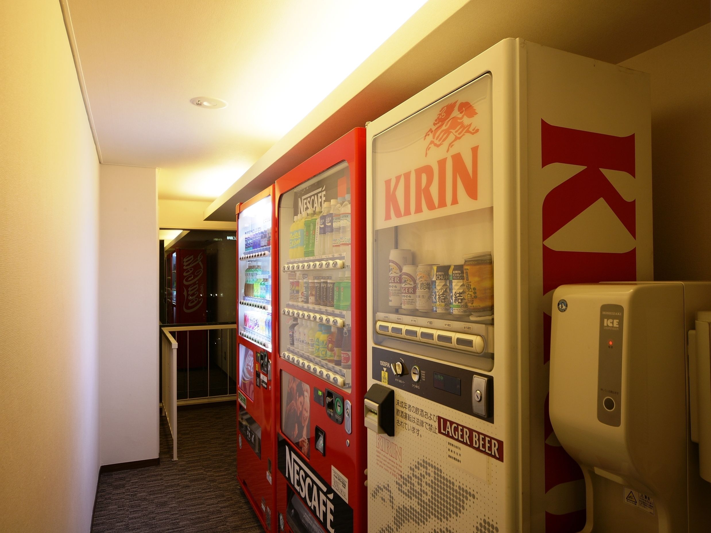 A vending machine area with options for Nescafe and Kirin beverages, and a nearby ice dispenser.
