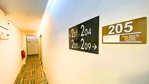A hotel hallway with directional signs for room numbers 201-204 and 205-209, and a sign requesting to make up the room. - Seeds Hotel Setiawangsa (Ampang)