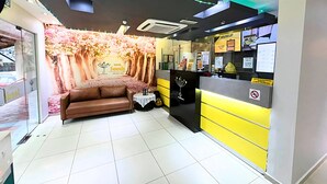 A hotel reception area with a sofa, a desk, and a backdrop of a waterfall. - Seeds Hotel Setiawangsa (Ampang)