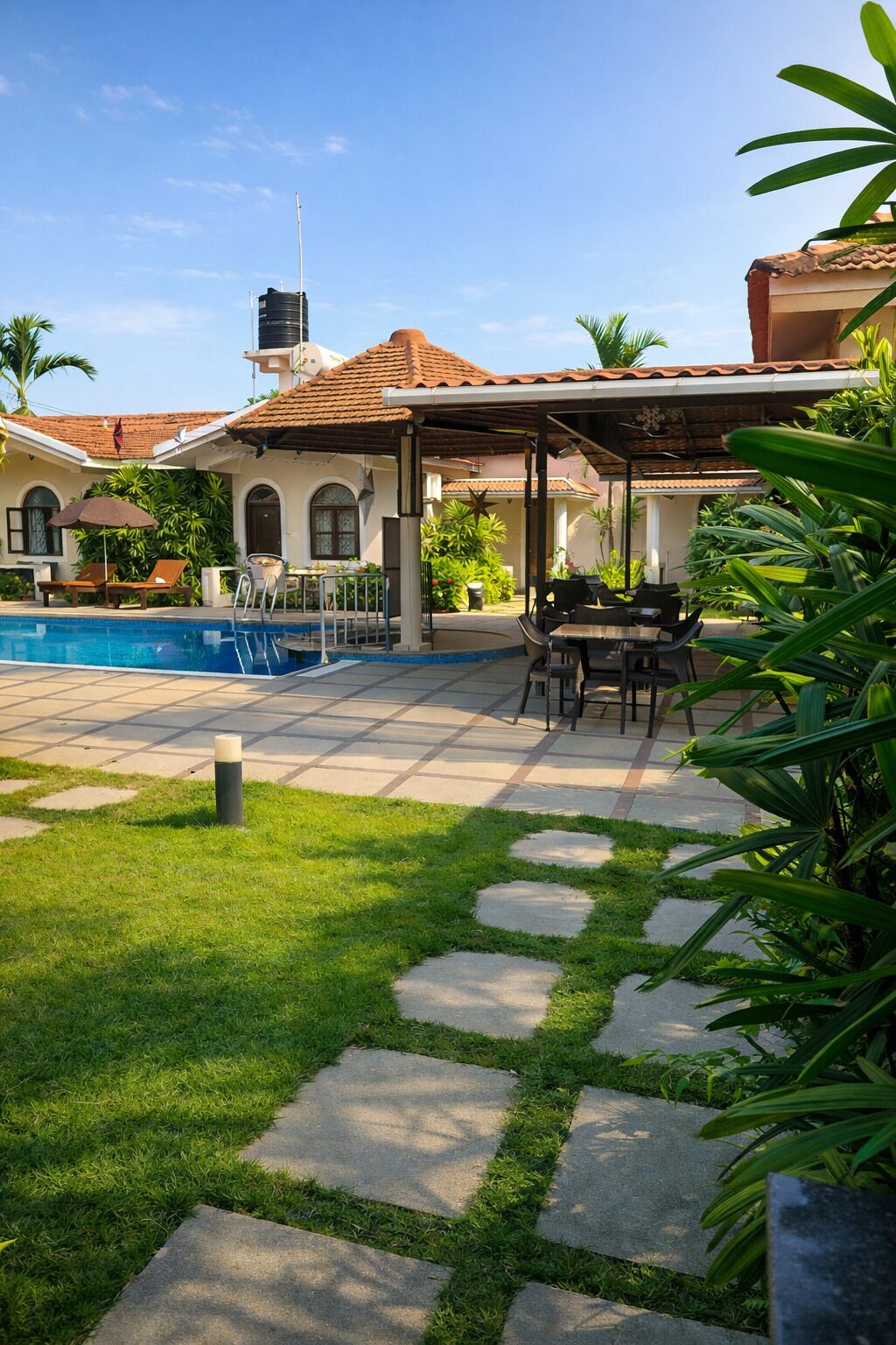 Zona de piscina con patio, mobiliario exterior y una sección cubierta.