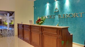 A reception desk at Jack's Resort with a teal wall and a laptop on it. - Jacks Resort (Vagator)