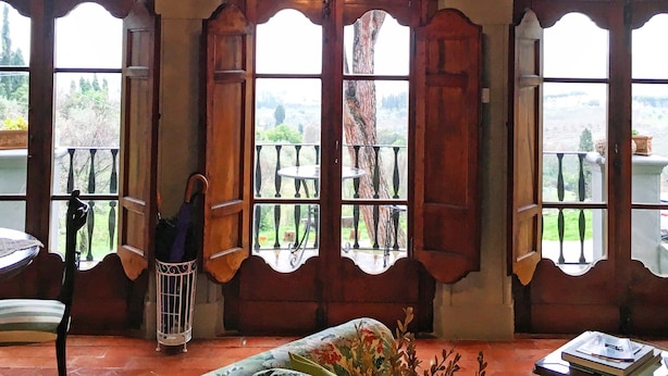 A room with a chandelier, arched windows, and a view of the outdoors. - Villa Colle Olivi (Pescia)