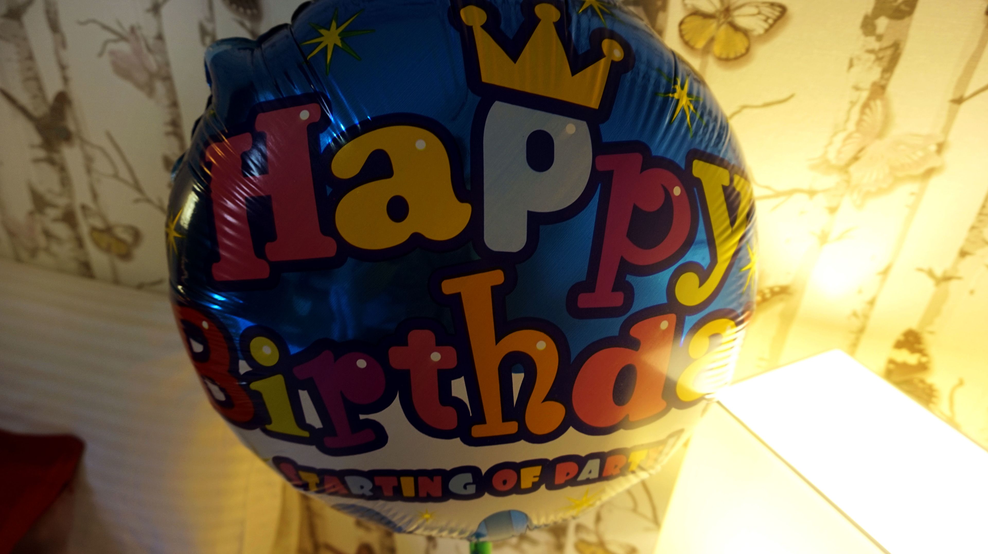 Un globo azul con la leyenda 'Happy Birthday' y 'Celebrating of Dreams' impresas.