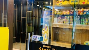 Een hotel ingang met een 'Smile' bord, een 'Royalty Program' banner en een 'Tolak Push' bord.