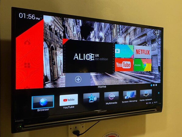 Ein Fernseher zeigt einen Startbildschirm mit verschiedenen App-Symbolen, darunter YouTube und Netflix, sowie eine Uhrzeit von 13:56 Uhr.
