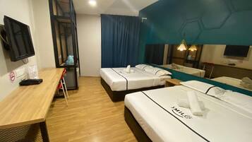A hotel room with two beds, a desk, a TV, and a bathroom.