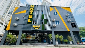 Een modern hotel met een opvallend 'HOTEL'-bord, airconditioning en een 'SMILE'-logo.