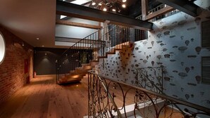 A staircase with a metal railing, wooden steps, and a wall with a pattern of hot air balloons.