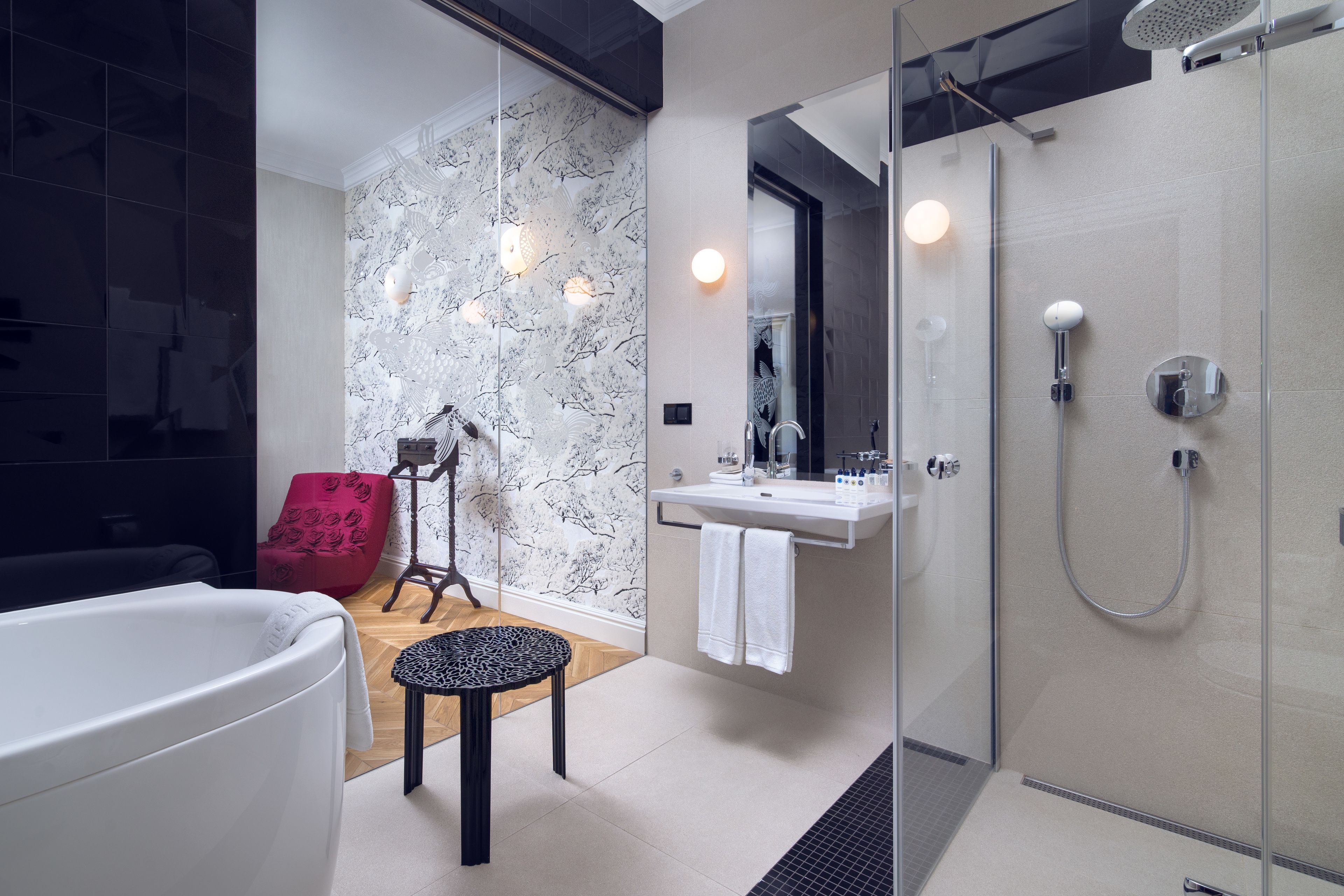 A modern bathroom with a glass-enclosed shower, a white bathtub, and a vanity with a mirror.