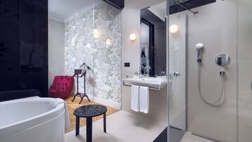 A modern bathroom with a glass-enclosed shower, a white bathtub, and a vanity with a mirror.