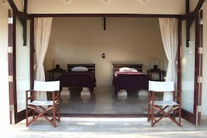 A room with two beds, a small table, and two chairs.