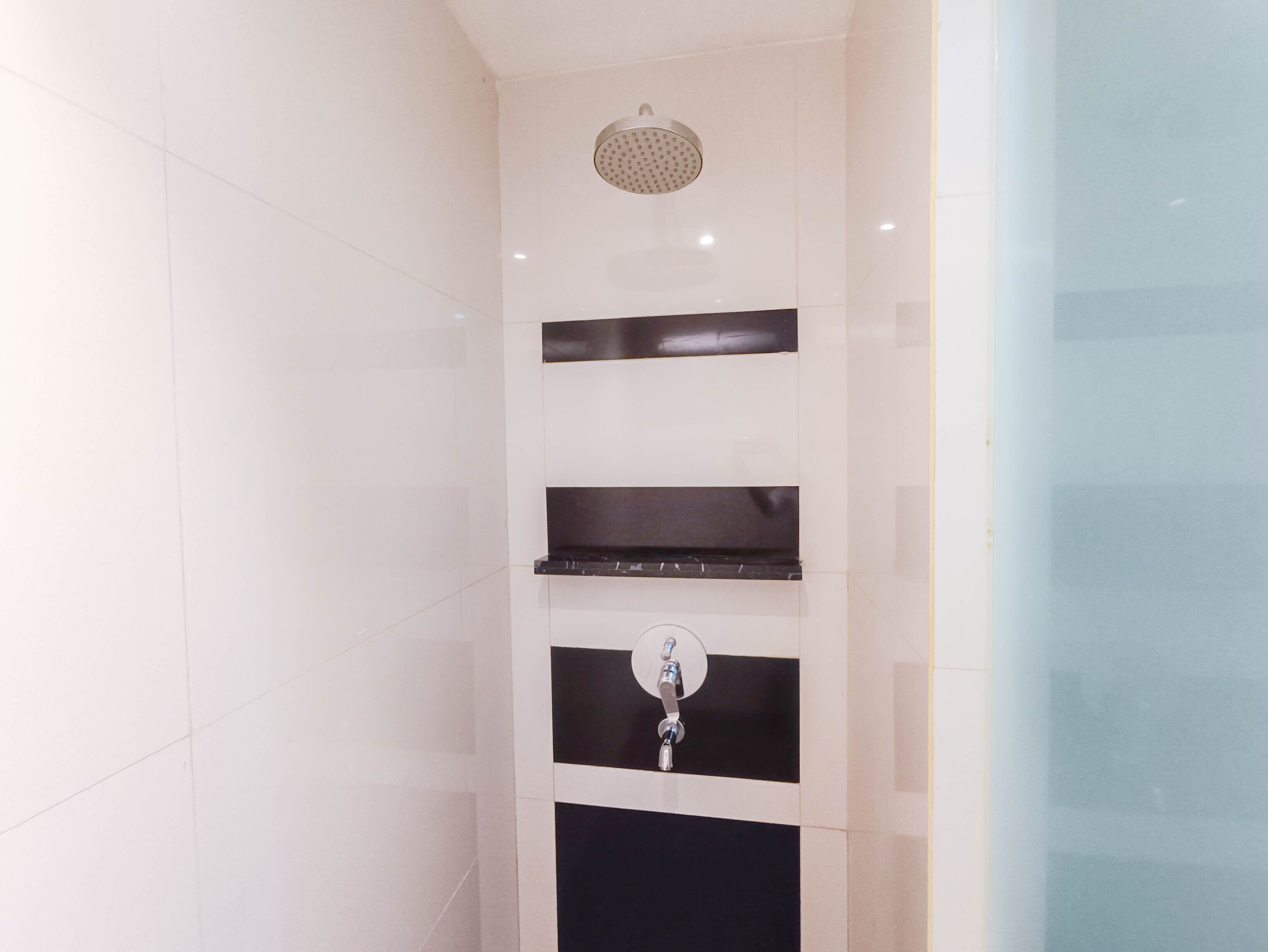A bathroom with a shower, a mirror, and a towel rack.