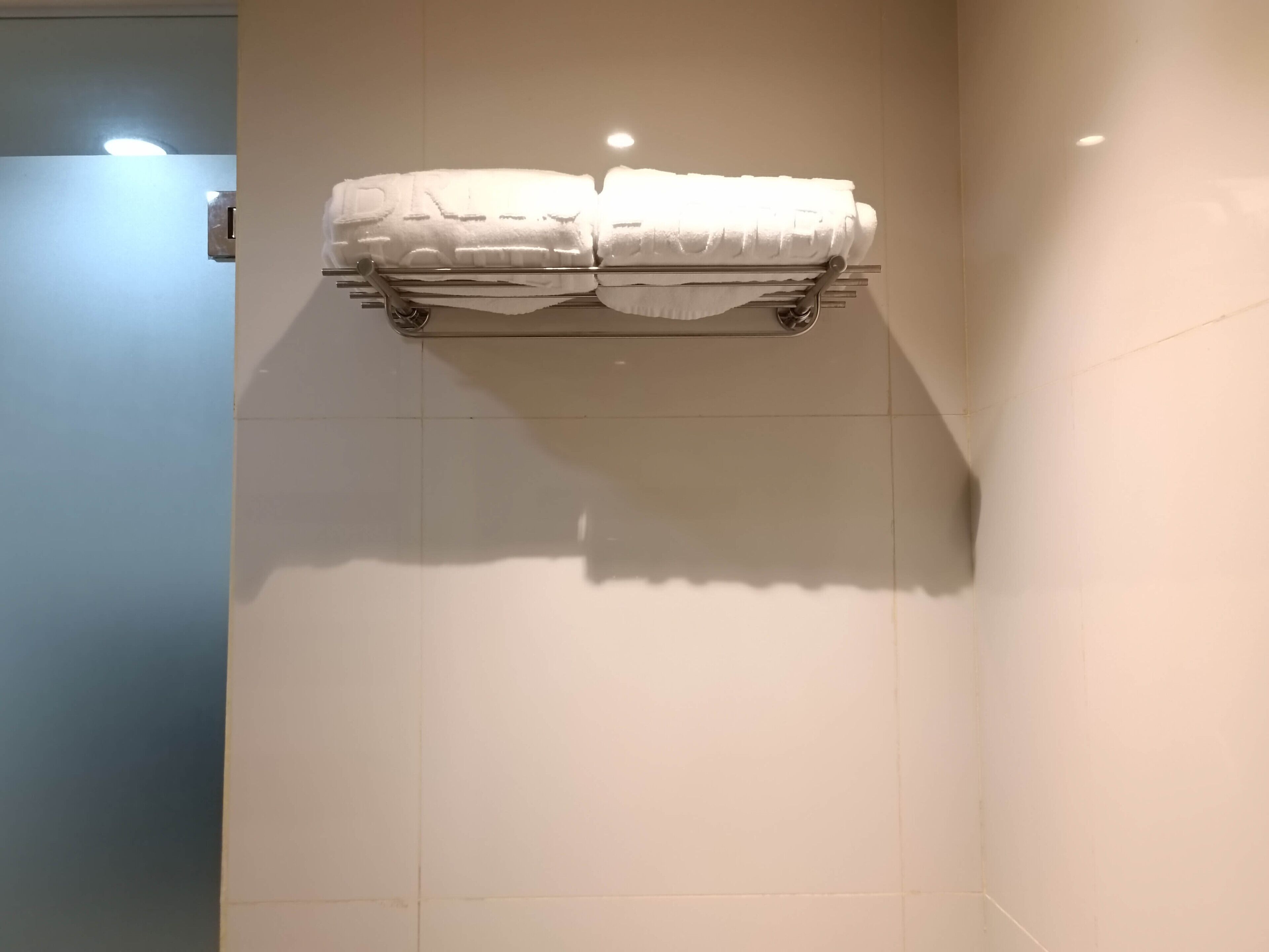 Een badkamer met een handdoekrek met twee handdoeken.