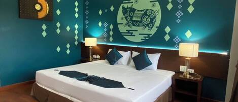 A hotel room with a large bed, two bedside tables, a wall mural, and a wooden floor.
