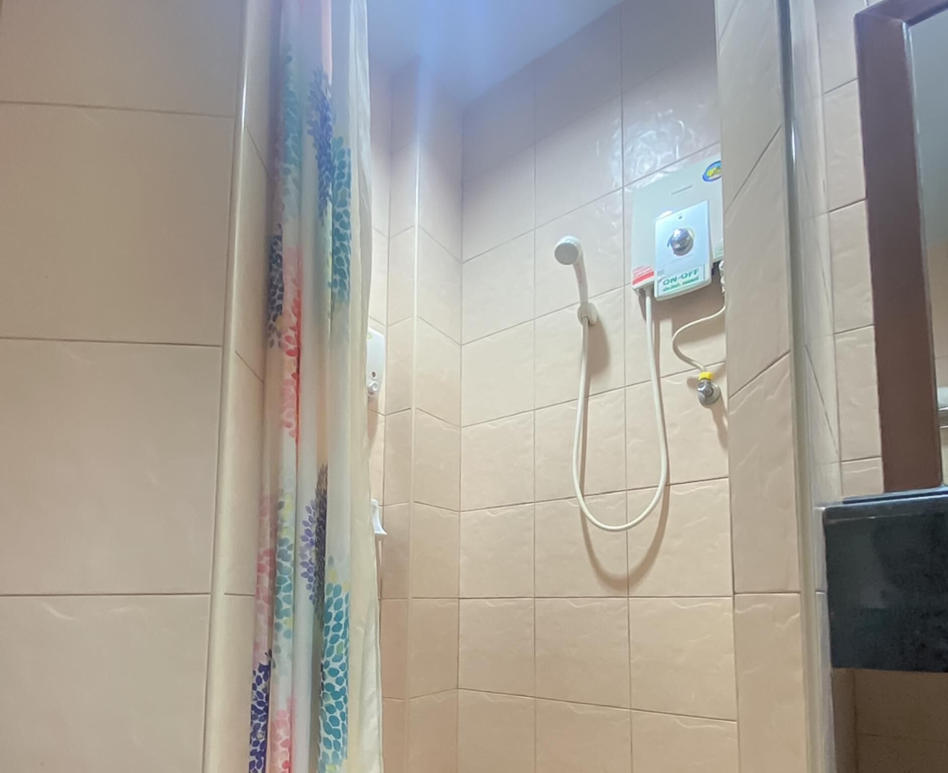 A shower with a control panel and a showerhead.