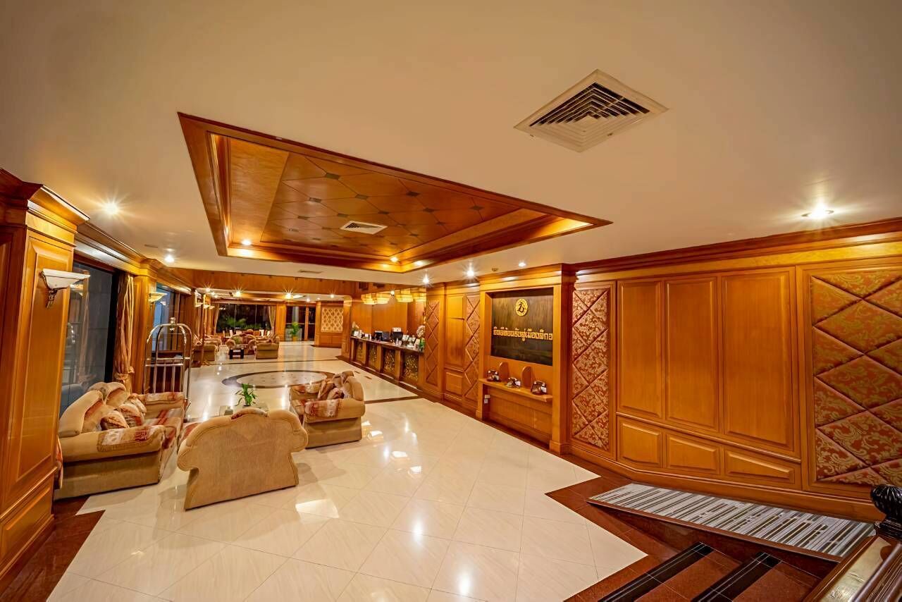 A spacious lobby with a high ceiling, a central seating area, and a reception desk.