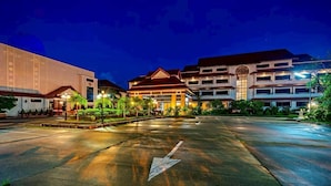 Un hotel con un estacionamiento amplio, varias construcciones y senderos bien iluminados.