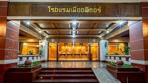 A hotel entrance with a reception desk, steps leading up to it, and a sign above. - The Ligor City Hotel (Nakhon Si Thammarat)