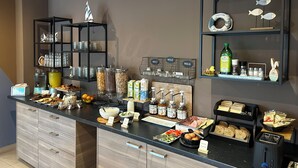 A breakfast buffet with various food items, condiments, and beverages. - Ostello del Porto (Lovere)
