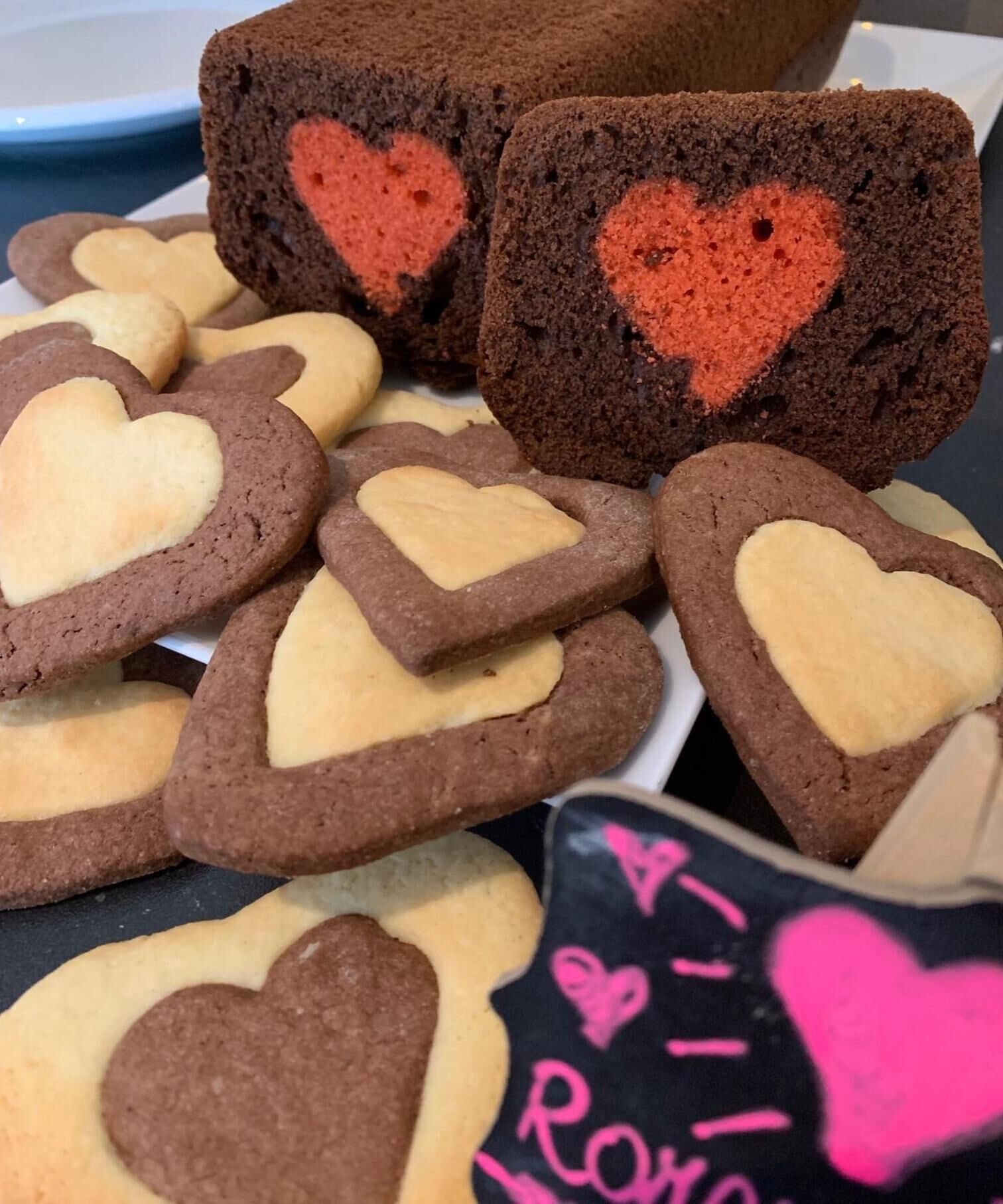 Diversos biscoitos em formato de coração e um pão com desenho de coração em cima.