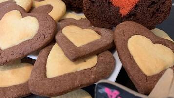 Diversos biscoitos em formato de coração e um pão com desenho de coração em cima.