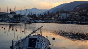 Un port de plaisance avec des bateaux amarrés, une eau calme et des bâtiments en arrière-plan.