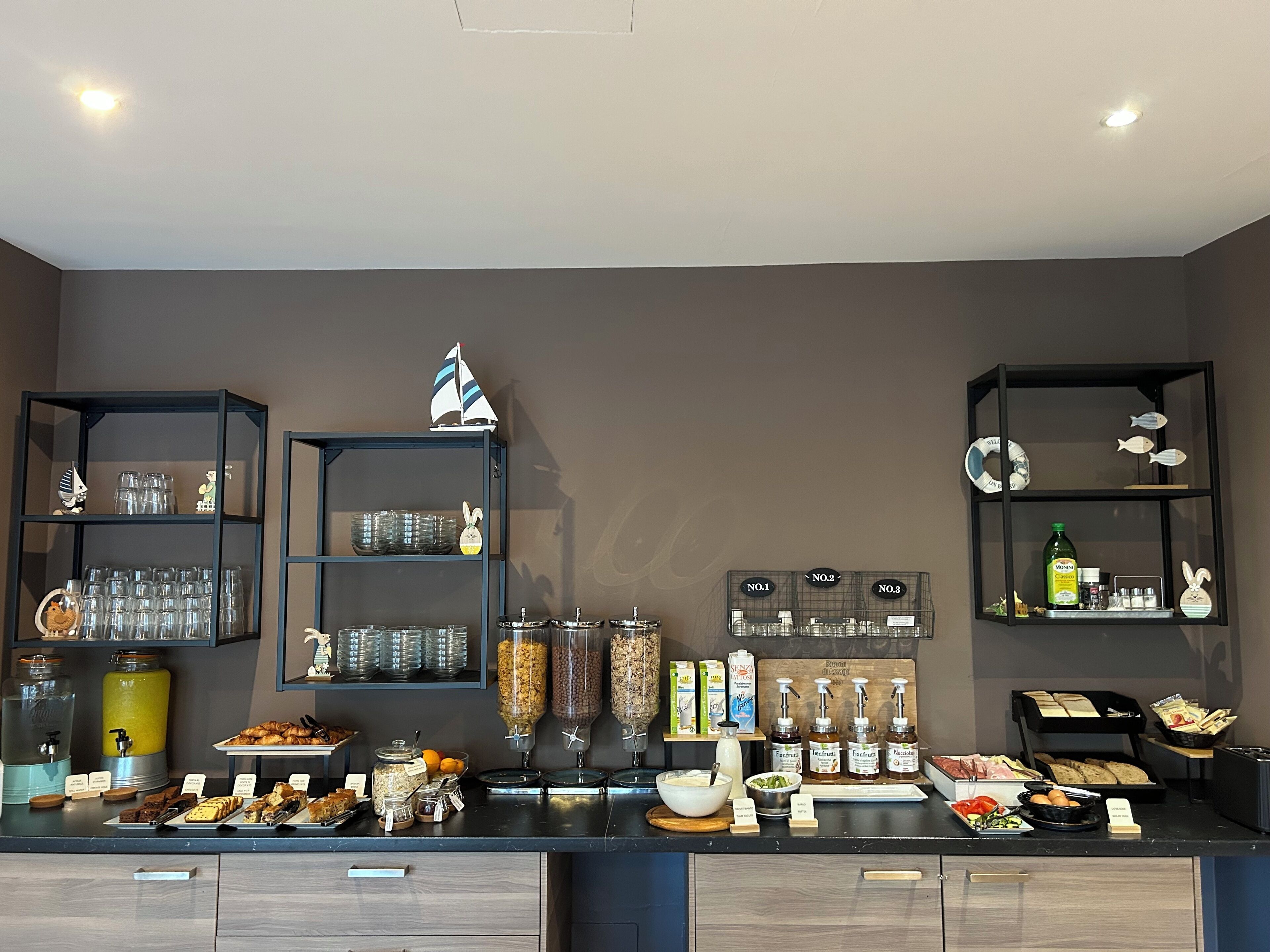 A buffet setup with various food items, condiments, and beverages.