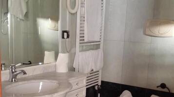 Ein Badezimmer mit Waschbecken, Spiegel, Toilette und Bidet.