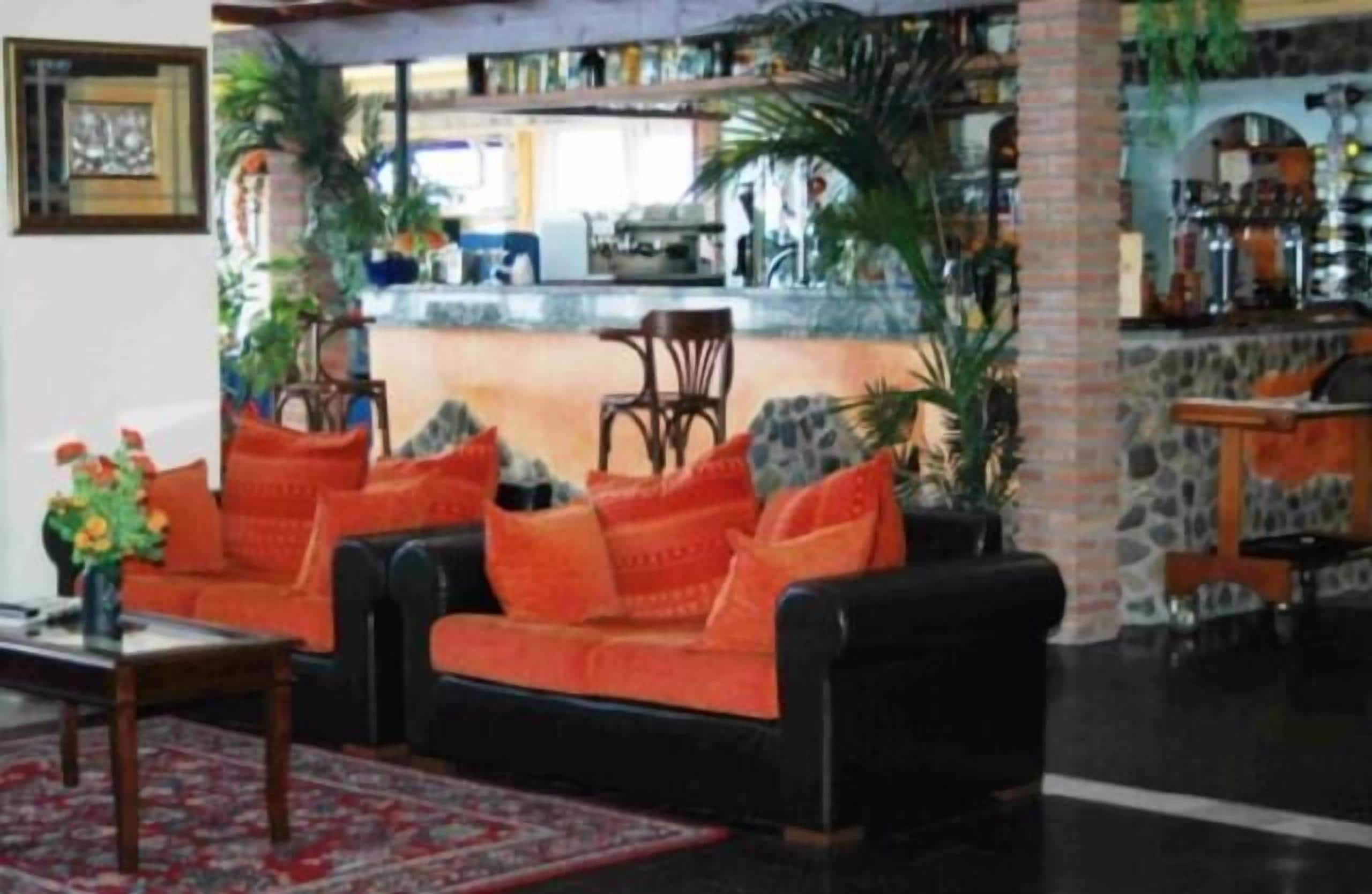 A living room with a sofa set, a coffee table, and a red rug.